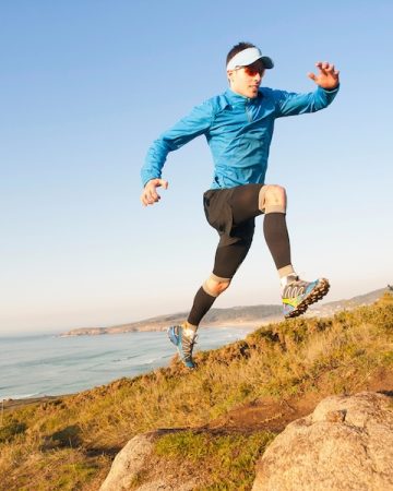 Man practicing trail running in a coastal landscape